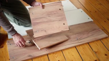 Bir zanaatkar ustalıkla vidayı düzgün, tahtadan bir tahtaya yerleştirir ve gerçek bir işçilik sergiler.