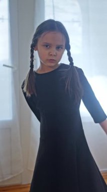 Çarşamba konsepti. Çarşamba Dansı. Dikey video. Çarşamba Addams kostüm giyen genç kız siyah bir elbise içinde dans ediyor. Ağır çekim. Dikey video. Yüksek kalite 4k görüntü