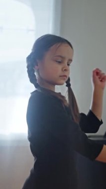 Siyah elbiseli, çarşamba Addams kostümlü çocuk siyah bir elbise içinde dans ediyor. Çarşamba konsepti. Çarşamba Dansı. Ağır çekim. Yüksek kalite 4k görüntü