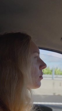 Gündüz vakti araba kullanan genç bir kadının huzurlu ve huzurlu bir profili.