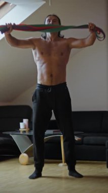 Formda bir birey, dayanıklılık eğitimi için özel olarak tasarlanmış bir dizi direnç bandı egzersizi gösteriyor.