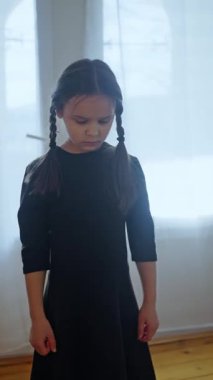 Siyah elbiseli kız ürkütücü bir şekilde kameraya bakıyor, Cadılar Bayramı için giyinmiş. Childs perili evde hayalet cadılar bayramı kostümü. Esrarengiz çocuk, siyah elbiseli kız korkutuyor. Korku, Thriller. 4k