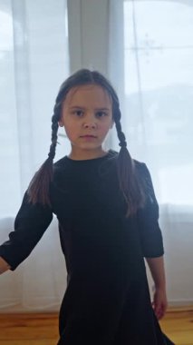 Neşeli örgülü neşeli bir çocuk güneşli bir odada neşeyle dans eder, saf masumiyet ve mutluluğu yakalar. Ağır çekim. Yüksek kalite 4k görüntü