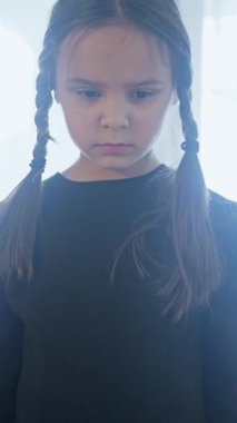 Büyüleyici siyah elbiseli genç bir kız yaratıcı bir şekilde poz veriyor, neşeli kişiliğini sergiliyor.