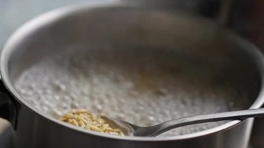 Bir tencerede mükemmel dokuya ulaşmak için pirinç kaynatırken içerik için tüm pişirme sürecini yakalıyor.