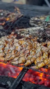 Kömür mangalında cızırdayan, sulu ızgara tavuk, nefis ve ağız sulandırıcı bir yemek pişirme süreci sergiliyor.