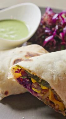 Lezzetli, sağlıklı ve renkli sebzeler ustalıkla hazırlanmış ve keskin yeşil sos ve taze lahana salatasıyla servis ediliyor.