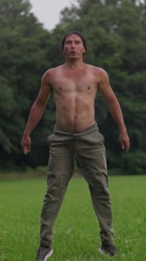 Formda bir birey, yemyeşil bir alanda bir dizi çömelme hareketi yapar. Gücünü ve çevikliğini gösterir..