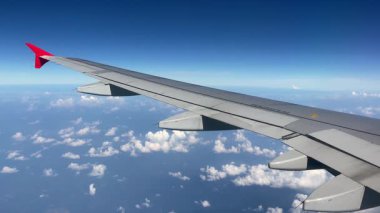 Nefes kesen hava manzarası güzel bir uçak kanadı gösteriyor kabarık bulutlar ve canlı mavi gökyüzü üzerinde süzülüyor. Fluffy Clouds 'un çarpıcı hava görüntüsü ve uçuş sırasında yakalanan bir uçak kanadı. 4k