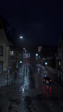 Islak kaldırımları ve parlayan ışıklarıyla büyüleyici bir gece sokak sahnesi dingin bir havayı çağrıştırıyor. yavaş çekim