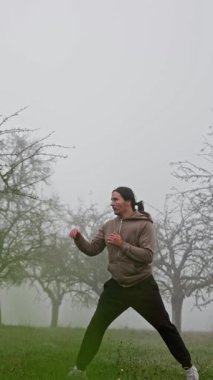Yetenekli bir dövüş sanatçısı, güçlü ve etkileyici tekniklerini güzel sisli bir açık havada sergiliyor.