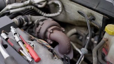 Görüntü, bir turbo şarj cihazının ve bir aracın motor bölümündeki araçların daha iyi anlaşılması için yakın çekimini gösterir.