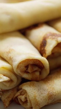 Çeşitli tatlı ve lezzetli dolgu seçenekleri için mükemmel bir şekilde uyan yuvarlanmış krep yığını.