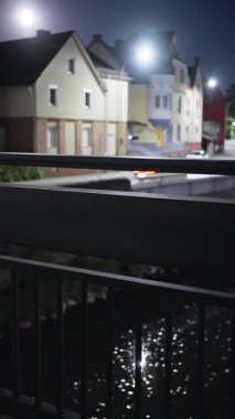 Huzurlu bir gece sahnesi, sakin bir ortam için mükemmel, yumuşak ışıklandırılmış binaları olan bir nehir kıyısını gösteriyor. Güzel Aydınlatılmış Binalarla Huzurlu ve Huzurlu Bir Nehir Kıyısı Görüş Alanını Deneyin