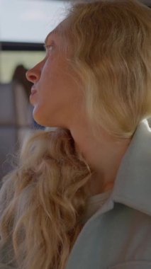 Uzun, dalgalı saçları olan genç bir kadın tren yolculuğunun tadını çıkarırken pencerenin kenarında huzur içinde dinleniyor. Yavaş çekim