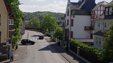 Canlı ağaçlar ve büyüleyici evlerle dolu huzurlu bir şehir caddesi. Huzurlu bir yaşam tarzı sergiliyor.