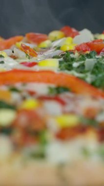 Renkli sebzeler ve aromatik otlarla kaplı ağız sulandıran bir pizza. Tüm yemek severler için mükemmel. Ağır çekim. Yüksek kalite 4k görüntü