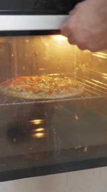 Çeşitli canlı malzemelerle taze pişmiş pizza modern bir fırında pişiriliyor ve yemek planlamak için mükemmel.