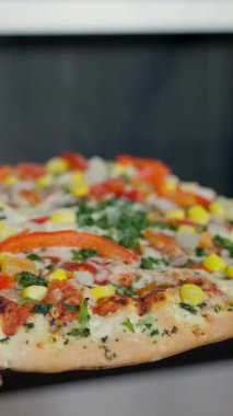 Renkli sebzeler ve aromatik otlarla kaplı ağız sulandıran bir pizza. Tüm yemek severler için mükemmel.