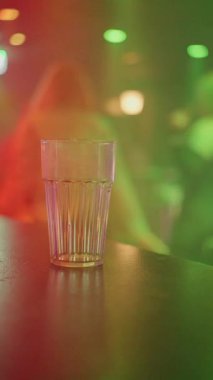 Canlı ve aydınlık bir bar sahnesi. Renkli gözlüklerle aydınlatıcı kulüp atmosferine karşı.