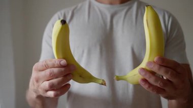 Yaratıcı bir sanatsal muz gösterisi, canlı renklerini ve eşsiz şekillerini sergileyerek ellerinde tutuluyor.