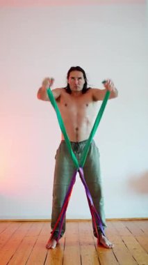 Atletik bir birey direnç bandı çalışmalarına katılır. Hem gücünü hem de esnekliğini arttırmak için.