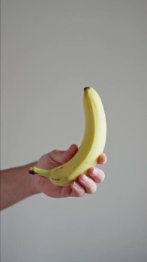 Beyaz Arkaplanda Muz Döndürme ve Döndürme Havada Askıya Alındı ve Beyaz Arkaplanda Bir Erkek El Tarafından Yakalandı, İzole Yavaş Hareket. Dikey video. Yüksek kalite 4k görüntü