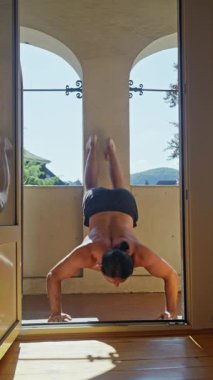 Güçlü bir adam etkileyici gücünü baş aşağı şınav çekerek sergiliyor.