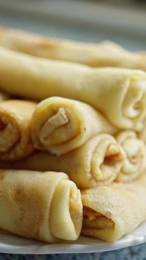 Lezzetli ve Lezzetli Rolled Crepes sunum için Beyaz Tabak 'ta Elegantly ayarlandı. Altın kenarlarını ve yumuşak dokusunu gözler önüne seren güzel sarılmış kreplerin büyüleyici bir görüntüsü. 4k