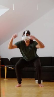 Sanal gerçeklik aktivitesine aktif olarak katılan bir kişi evdeki şaşırtıcı teknolojiyi gösteriyor. Bir VR kulaklık takarken Sanal Gerçeklik Deneyimi Yaşayan Bir Kişi. 4k