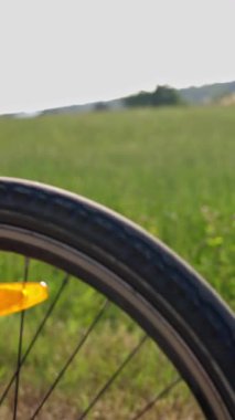 Zengin ve canlı yeşil bir arkaplana karşı detaylı bir bisiklet tekerleğinin yer aldığı yakın plan bir fotoğraf