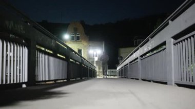 Geceleri köprüde koşan bir insan, açıkça zindelik seviyesini ve çevrendeki canlı şehir yaşamını gösteriyor. Ağır çekim. Yüksek kalite 4k görüntü