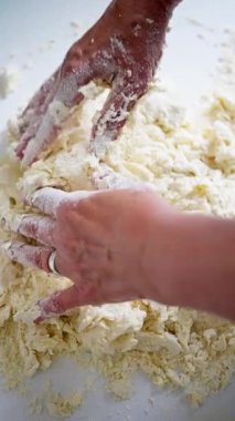 Hamuru ustalıkla yoğurup, karmaşık yemek hazırlama sanatını gözler önüne seren ellerin detaylı bir yakın çekimi.