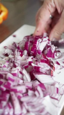 Uzman dilimlenmiş kırmızı soğanlar, yemek pişirmede ya da salata hazırlıklarında kullanılmak üzere mükemmel bir şekilde hazırlanmış.