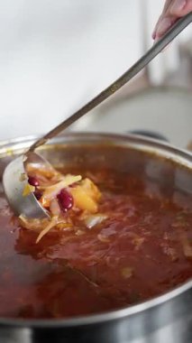 Ukrayna Borsch 'u. Yemek pişirme sürecinin altını çizerek, lezzetli bir çorbanın karıştırılıp zarif bir şekilde servis edildiği yakın plan bir çekim. Yüksek kalite 4k görüntü