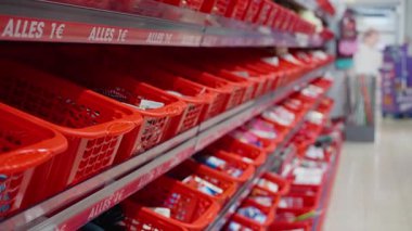 Parlak kırmızı sepetler, canlı bir perakende ortamında satılık çeşitli çekici eşyalarla doludur. Yüksek kalite 4k görüntü