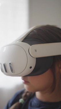 Genç bir çocuk renkli bir VR kulaklıkla neşeli bir sanal gerçeklik deneyimi yaşıyor.