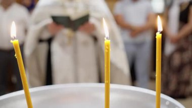 Dini bağlamda içten dualarla dolu anlamlı bir mum ışığı seremonisi. Titreyen mumları tasvir eden huzurlu bir an kutsal bir dini töreni aydınlatan sadık katılımcılarla birlikte. 4k