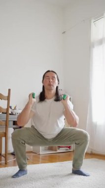 Fitness, resistance bands. A Man with workout in home in morning for arm muscle training. Health, wellness and male person with exercise equipment for warm up with recovery stretching in apartment. High quality 4k footage