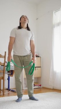 Direniş bantlarını kullanarak gücünü arttıran ve hareket kabiliyetini arttıran bir adam. Yüksek kalite 4k görüntü