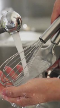 Elleri titizlikle durulandırılmış mutfak aletleri en uygun temizlik ve hijyen için akan suyun altında.