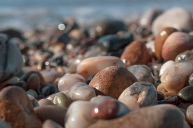 Sahilde farklı boyutlarda ve renklerde ıslak yuvarlak kayalar huzur ve huzur dolu bir atmosferde.