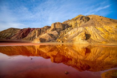 Mazarrn, Murcia, İspanya 'nın madencilik arazisinde çıkarılan minerallerin demirinden dolayı kırmızı bir su birikintisi görülebilir.