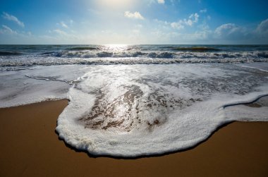 Atlas Okyanusu kıyısında köpüklü bir dalga Huelva sahilinde, parlak bir günde, İspanya