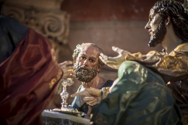 İspanya 'nın Murcia şehrinde Aziz Peter' ın yüzünün ön planda göründüğü Kutsal Cuma töreninde heykeltıraş Salzillo tarafından yapılan Son Yemek 'in heykel tahtının ayrıntıları.