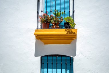 İspanya, Endülüs 'ün beyaz köylerinin tipik bir cephesi. Balkonları, mavi kepenkleri ve çiçekli saksıları var.