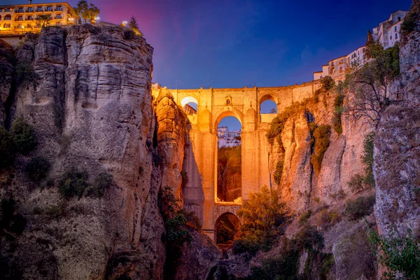 İspanya, Malaga, Ronda 'daki Yeni Köprü' nün muhteşem manzarası şehrin alt kısmından alacakaranlıkta aydınlandı.