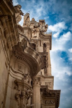 İspanya 'daki Santa Maria de Murcia Katedrali' nin ön cephesinde mimari detaylar ve heykeller içeren dikey fotoğraf ve kenar manzara.