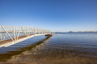 İspanya, Cartagena 'da bulunan Mar Menor' daki El Mar de Cristal 'in kristal plajı üzerinde demir köprü ve ahşap geçit.