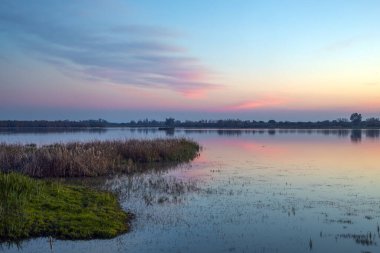 Gün batımında Doana Ulusal Parkı, Huelva, Anadalucia, İspanya 'da kuşlarla dolu güzel bir göl manzarası.